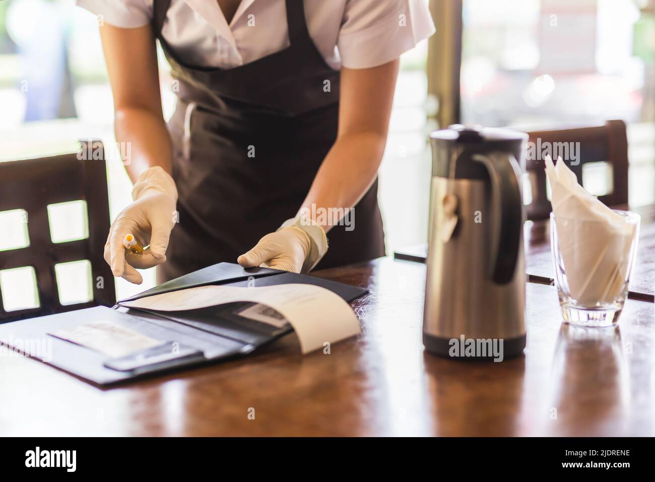Le serveur donne une facture au client dans le restaurant. Banque D'Images