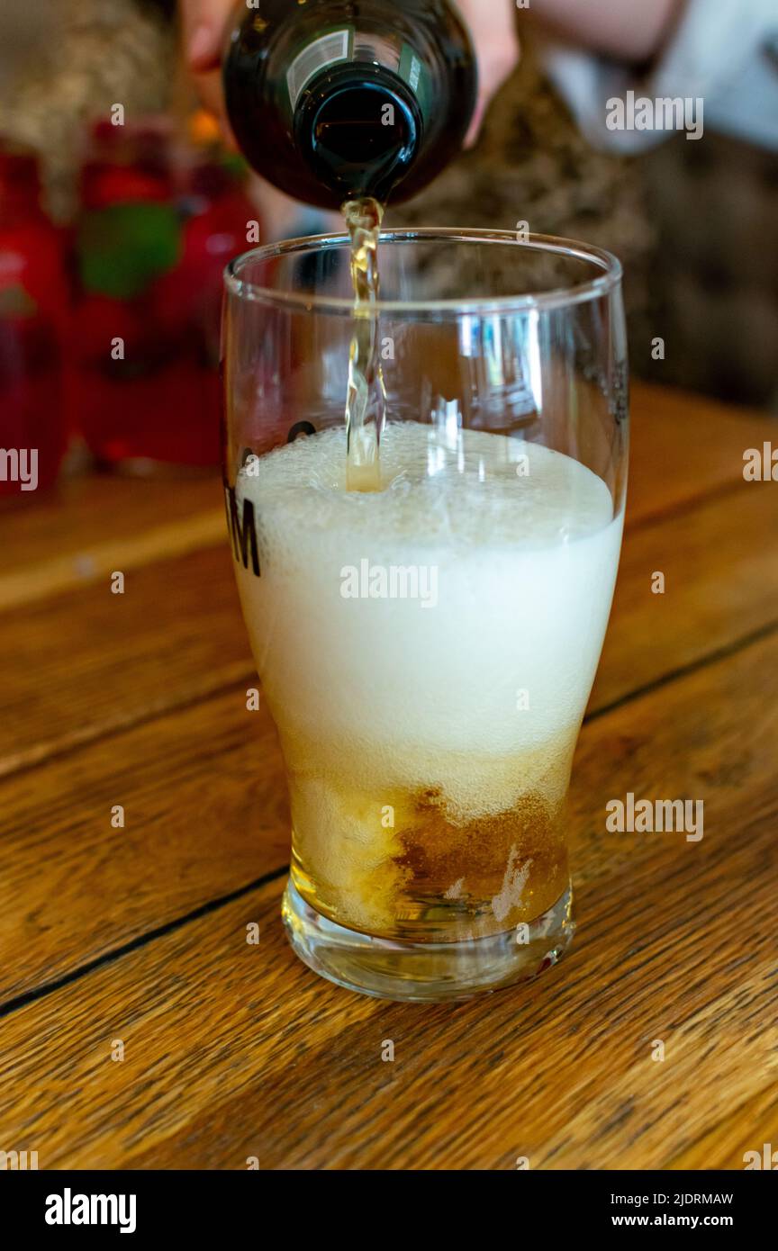 Verser la bière légère dans le verre du bar polonais Banque D'Images
