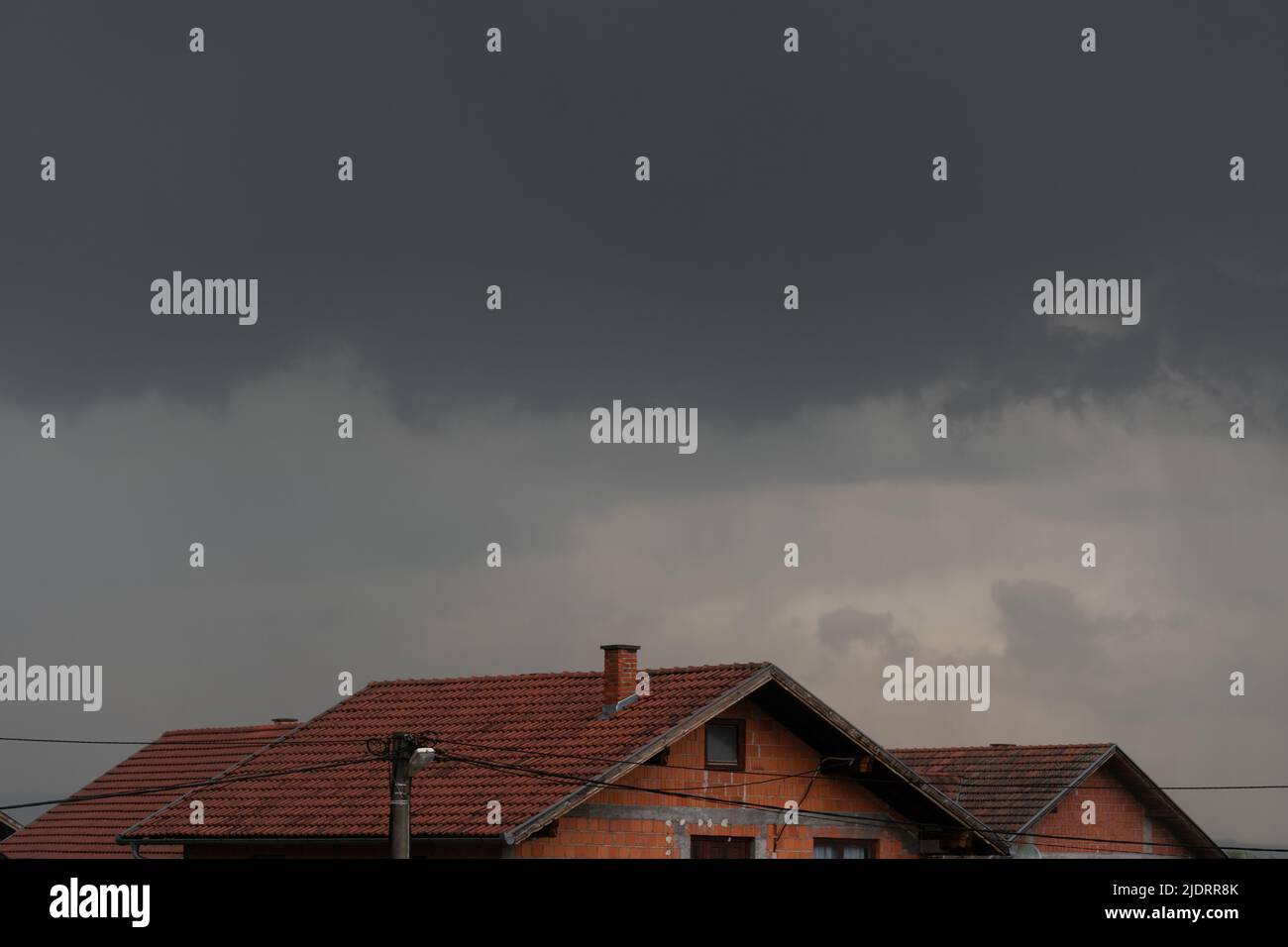 Des nuages sombres planaient sur les toits, des nuages orageux dans la banlieue Banque D'Images