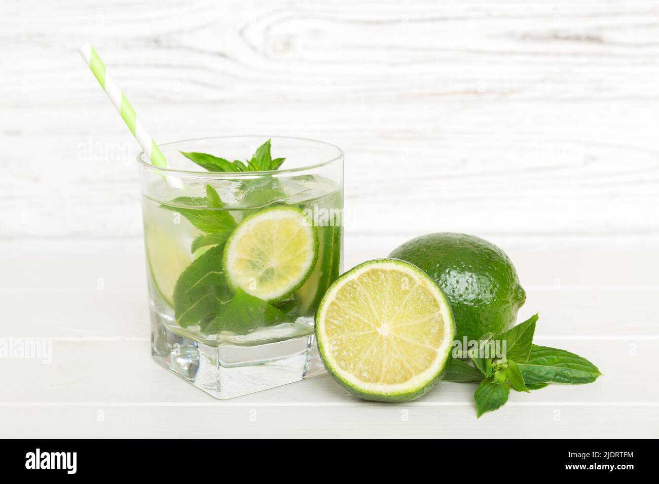 Cocktail Mojito. Cocktail rafraîchissant de mojito avec citron vert, citron et menthe dans un grand verre avec un bâton. Banque D'Images