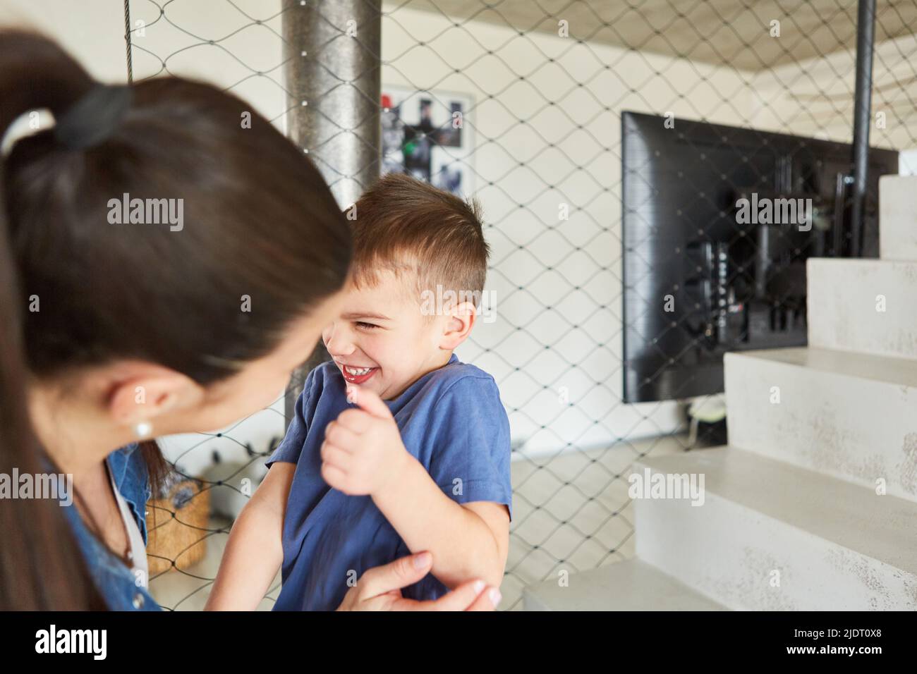 Maman et son fils ont le plaisir de faire des trompes et de se tromper autour de la maison dans le salon Banque D'Images