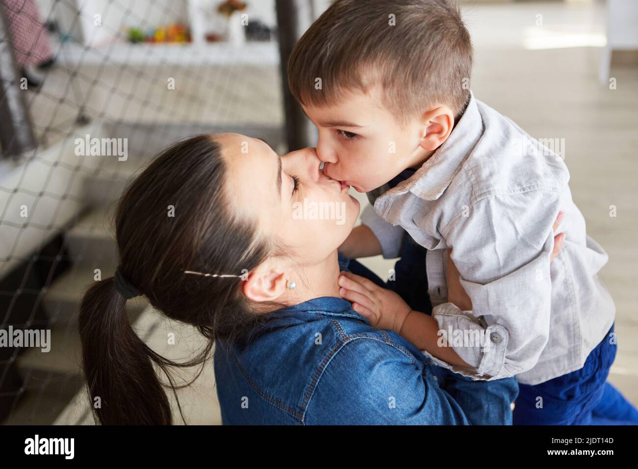 Mère et fils partagent un baiser affectueux pour l'amour et l'intimité maternels Banque D'Images