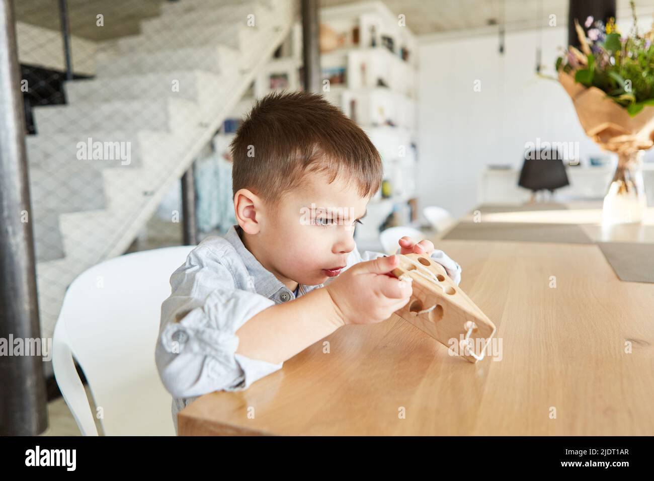 Petit garçon jouant de bons moteurs jeu éducatif avec des enfants en bois jouet Banque D'Images