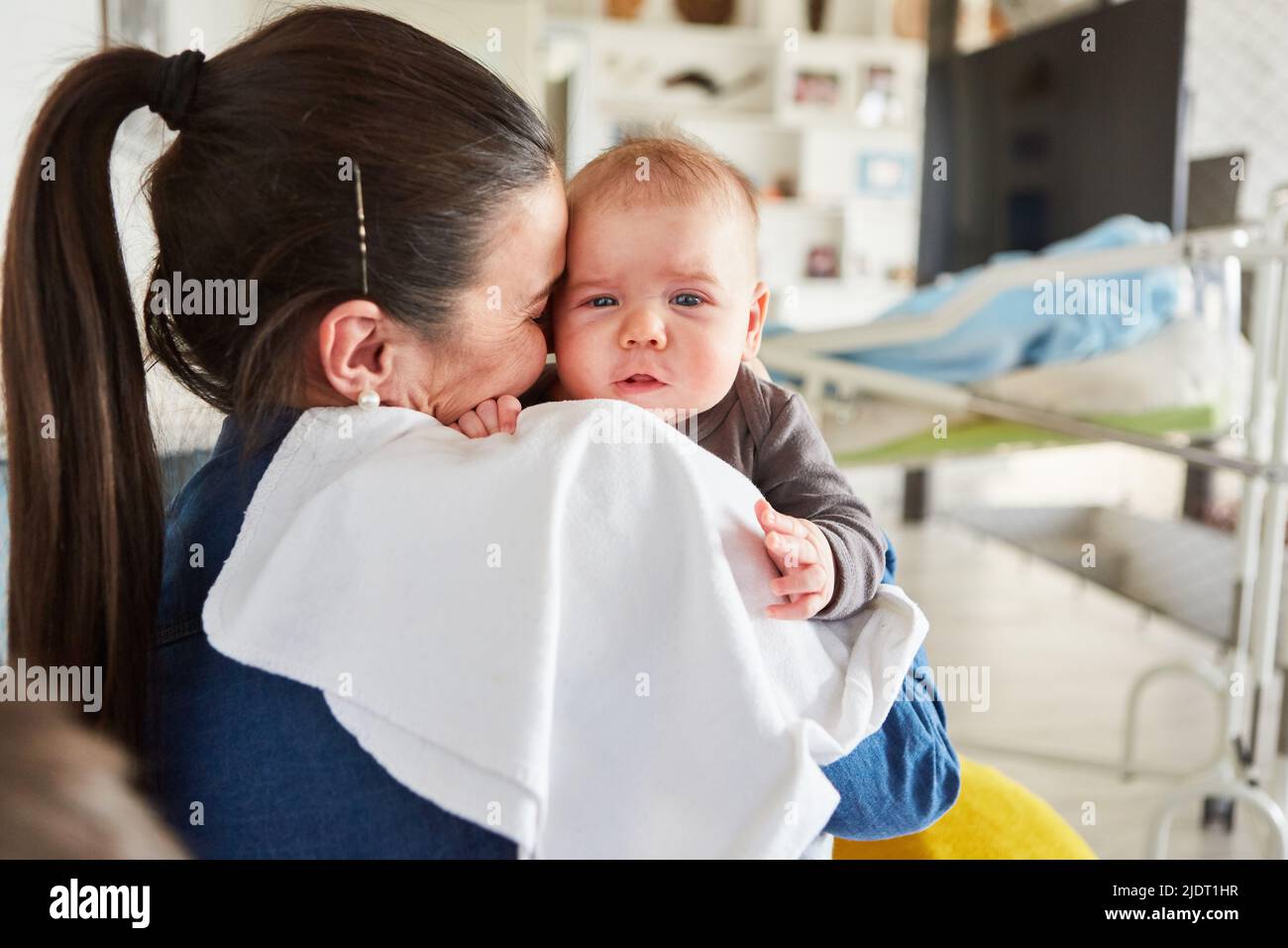 Mère aimante tenant bébé dans ses bras comme un concept de l'amour maternel et de la maternité Banque D'Images