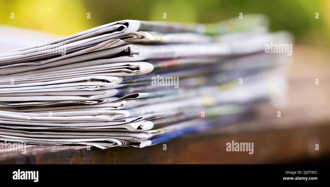 Pile de journaux sur une table en bois, bannière d'actualités quotidiennes Banque D'Images