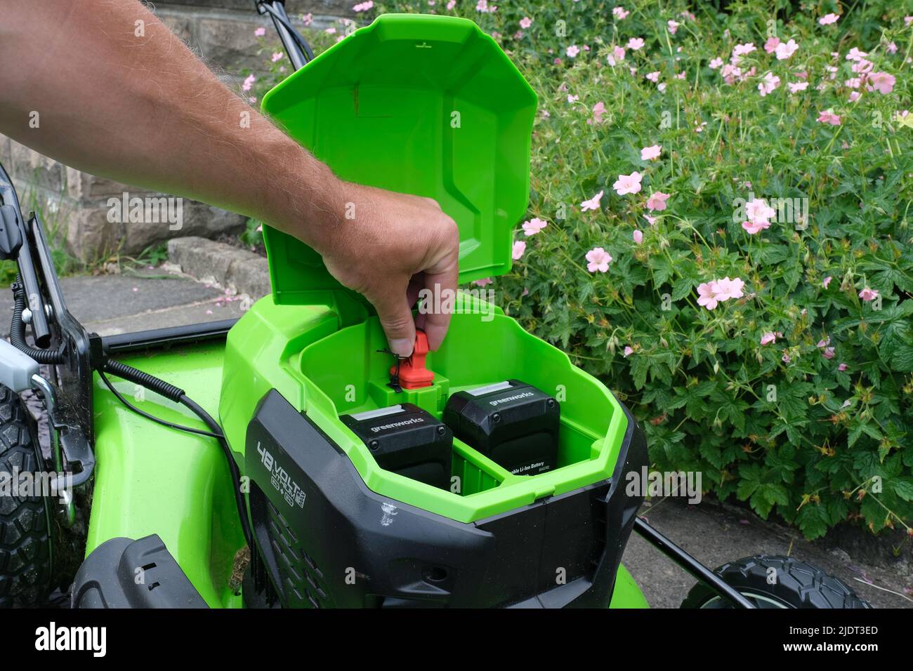 La fiche rouge d'une tondeuse à batterie Greenworks est un dispositif de sécurité. Banque D'Images