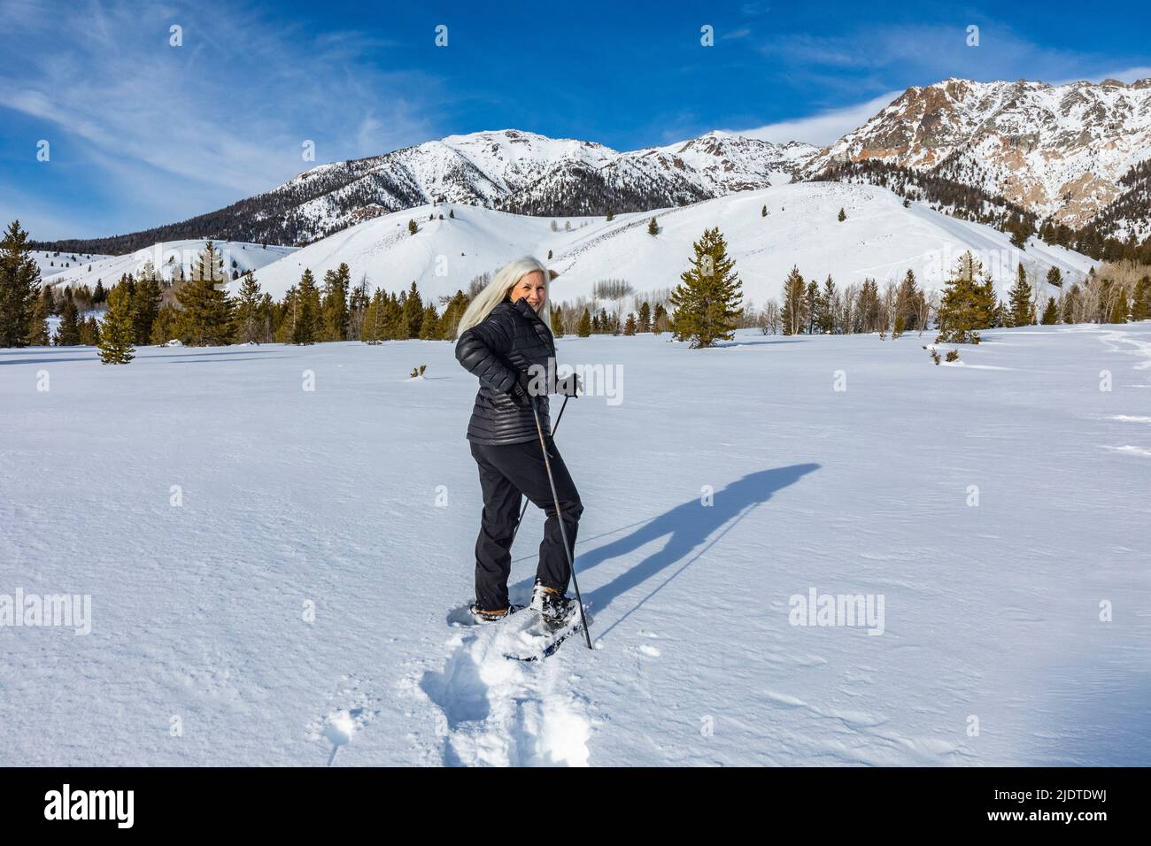 États-Unis, Idaho, Ketchum, femme blonde senior raquettes dans un paysage enneigé Banque D'Images