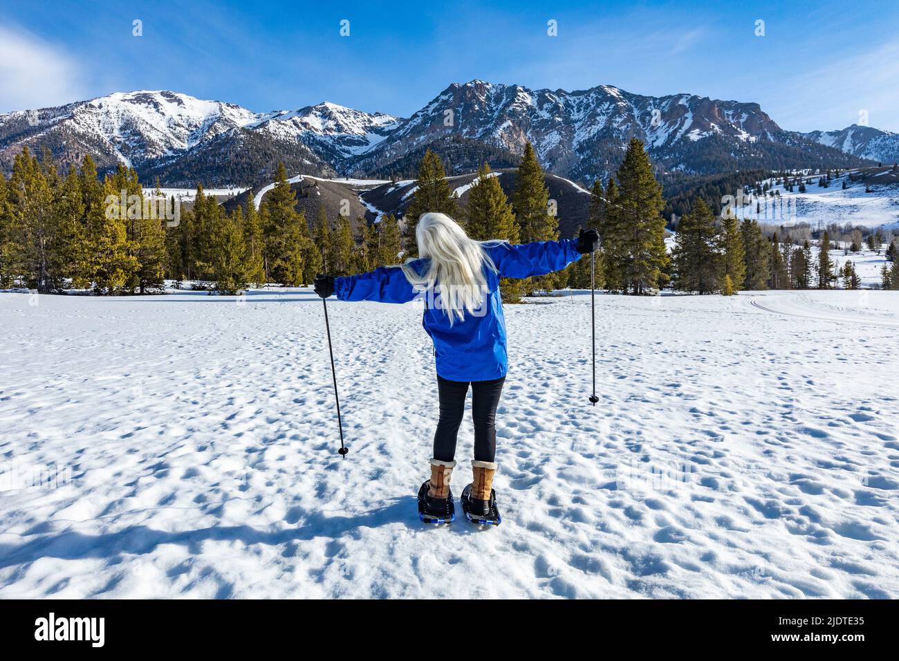 USA, Idaho, Ketchum, vue arrière de femme blonde senior avec raquettes dans le paysage Banque D'Images