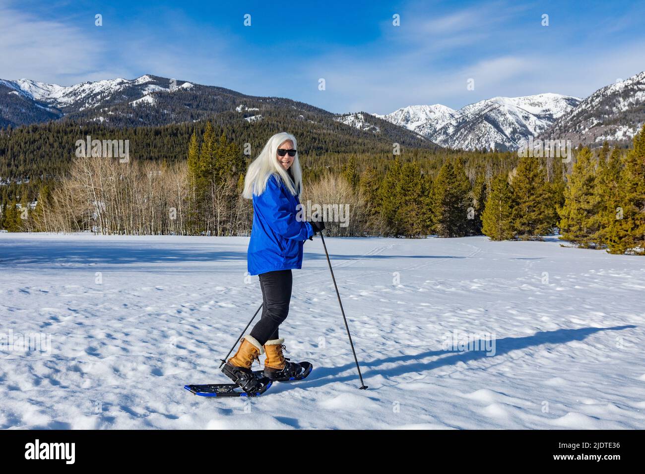 Etats-Unis, Idaho, Ketchum, Portrait de femme blonde senior en raquettes dans un paysage enneigé Banque D'Images