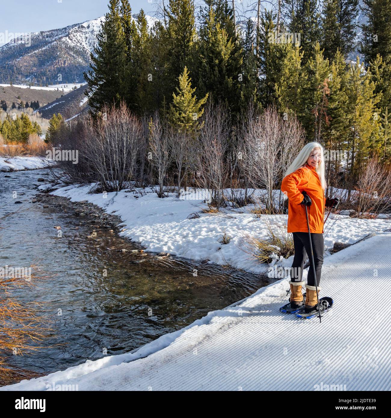 États-Unis, Idaho, Ketchum, femme blonde senior raquette dans un paysage enneigé Banque D'Images