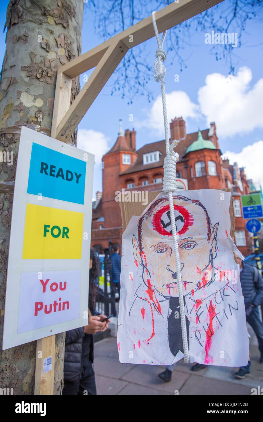 Des pancartes et des affiches contre le président russe Vladimir Poutine et son invasion de l'Ukraine sont visibles près de l'ambassade de Russie à Londres. Banque D'Images