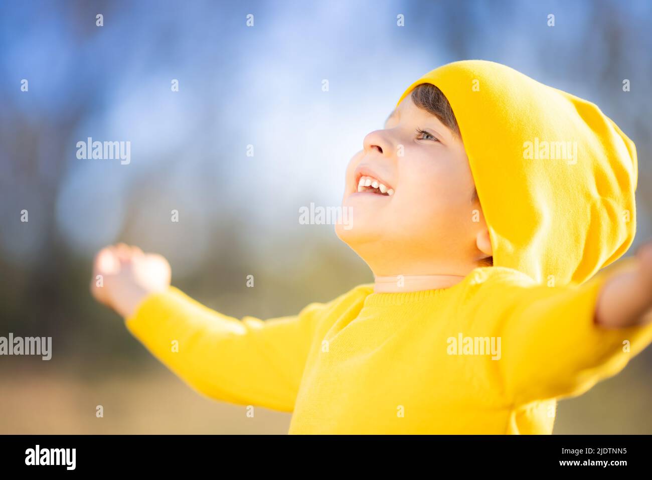 Portrait de l'enfant heureux sur fond de feuilles jaunes. Enfant souriant s'amuser en plein air dans le parc d'automne. Concept de liberté et d'imagination Banque D'Images