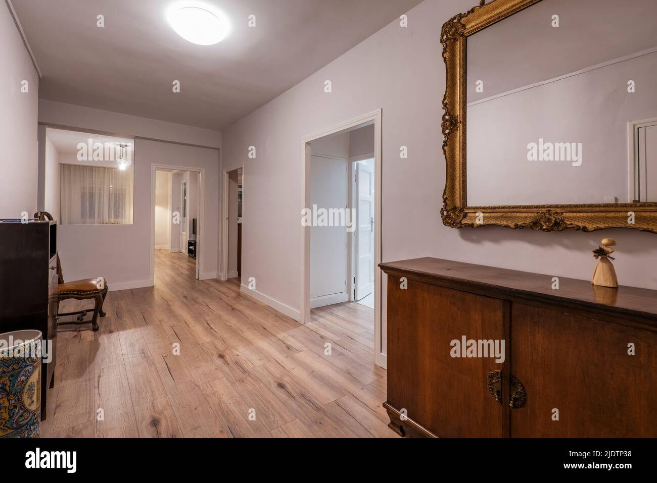 Couloir d'une maison de vacances avec un magnifique miroir à cadre doré, un panneau latéral de madra et un parquet en châtaignier Banque D'Images