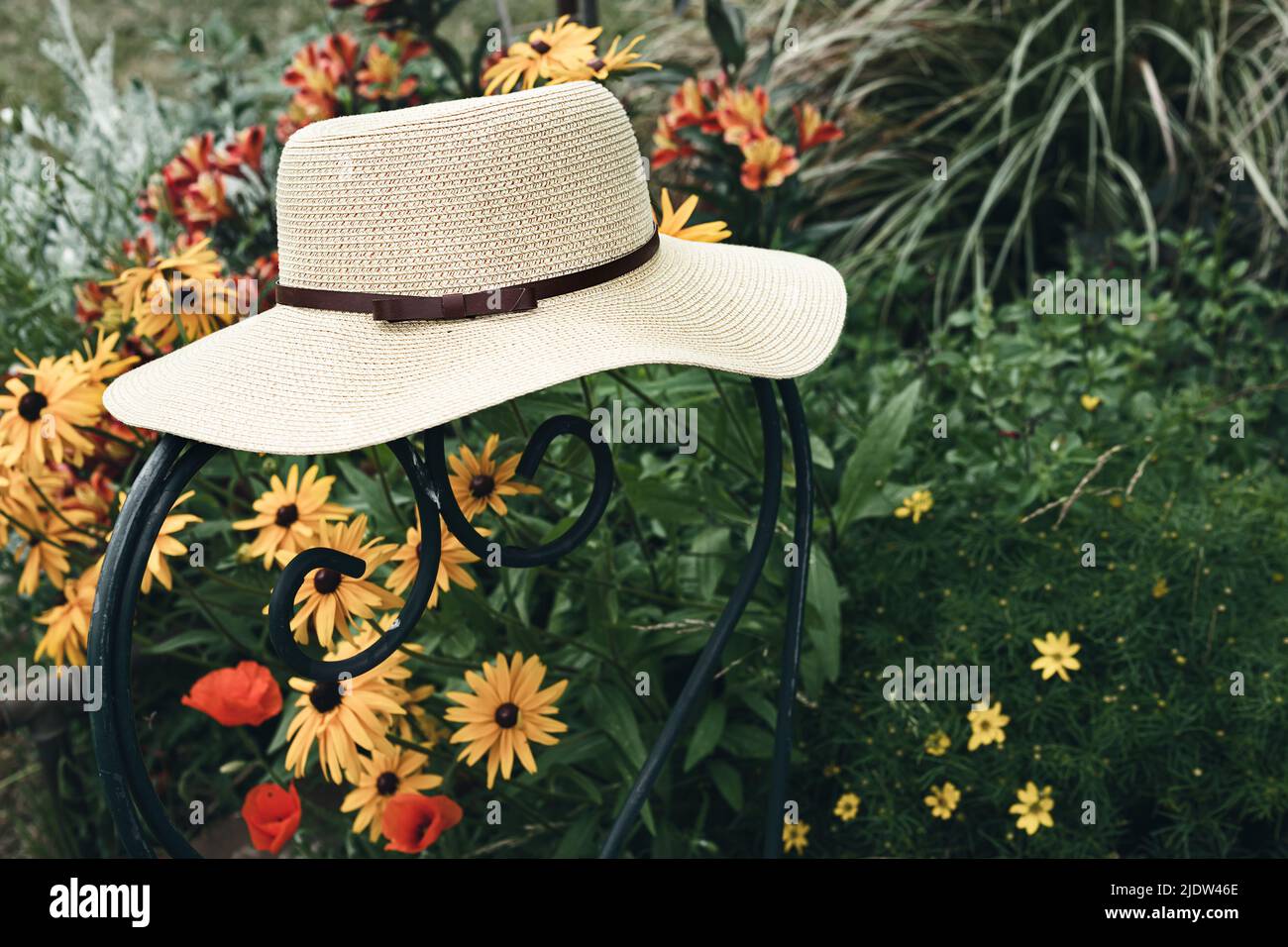Chapeau d'été pour femmes sur une chaise verte dans un jardin avec des  fleurs, la nature et le concept de vie lente Photo Stock - Alamy