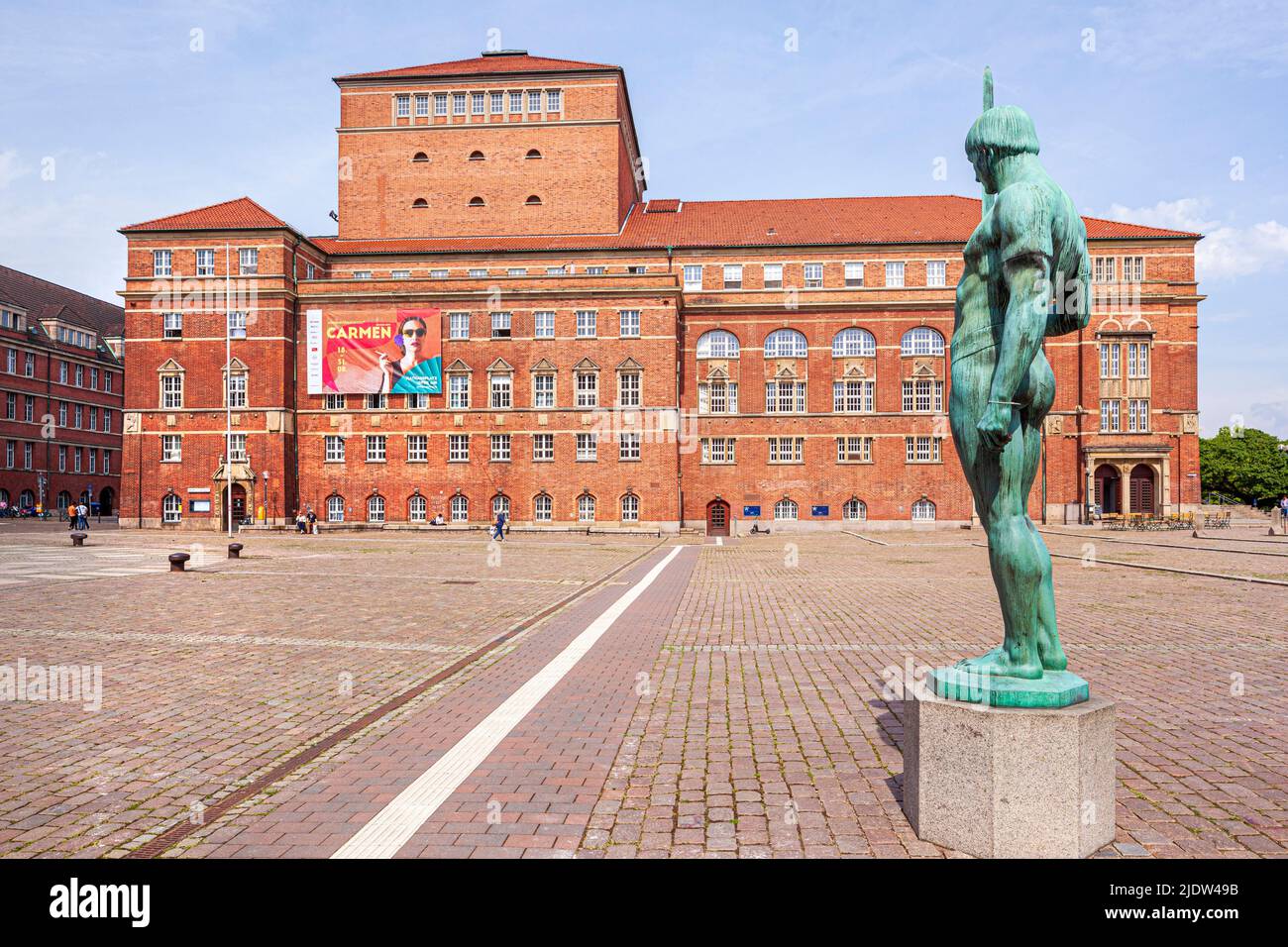 La statue de l'épée du porteur (Schwertträger) sur la place de Kieler Rathausplatz avec l'opéra de Kiel (Opernhaus Kiel) et le théâtre Kiel Banque D'Images