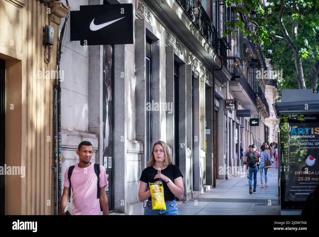 Des piétons marchent devant la marque américaine de vêtements de sport multinationaux Nike Store en Espagne. Banque D'Images