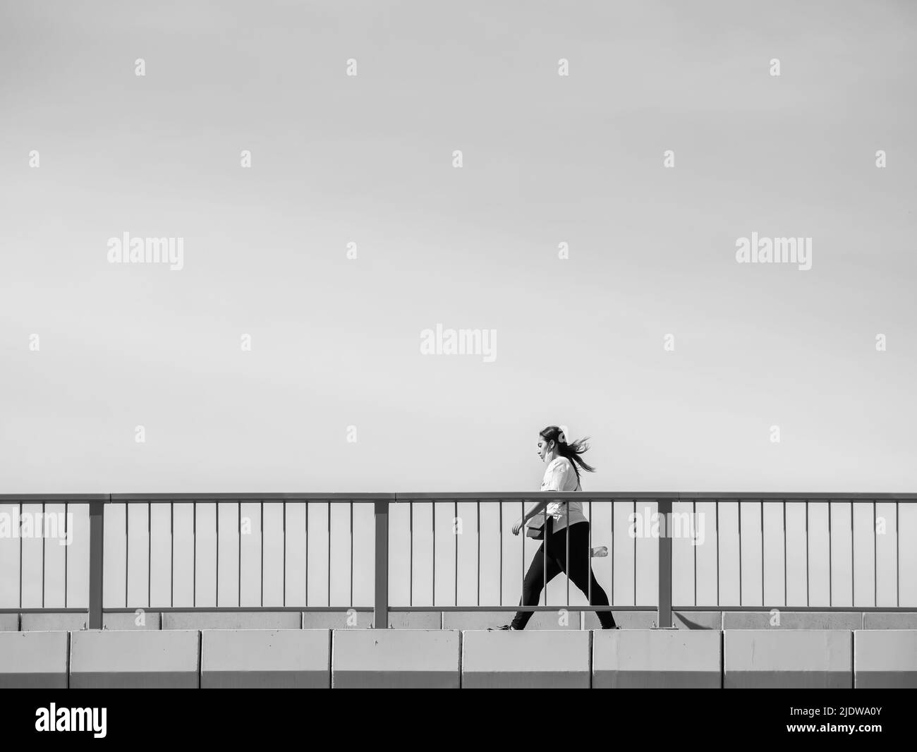 Bucarest, Roumanie - 05.20.2022: Femme traversant un pont. Photographie minimaliste abstraite Banque D'Images