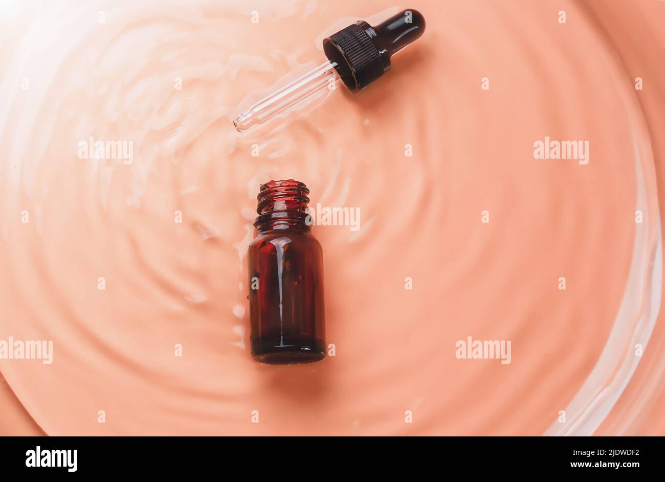 Laboratoire cosmétique abstrait. Flacons en verre ambré foncé sur fond liquide beige. Cosmétiques naturels pour les soins, homéopathie. Style plat, vue de dessus Banque D'Images