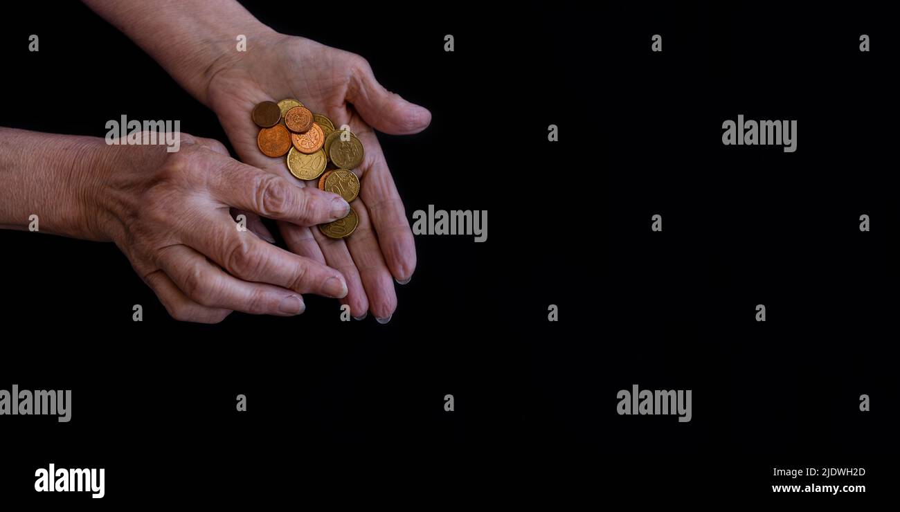Les mains des femmes en gros plan comptant des pièces dans les paumes. Copier coller, arrière-plan noir Banque D'Images
