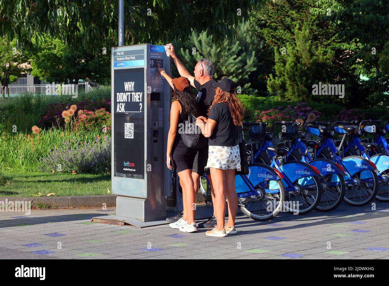 Touristes pointant sur la signalisation sur un kiosque Citibike dans Hudson River Park, New York City. Vélo part, location de vélo. Banque D'Images
