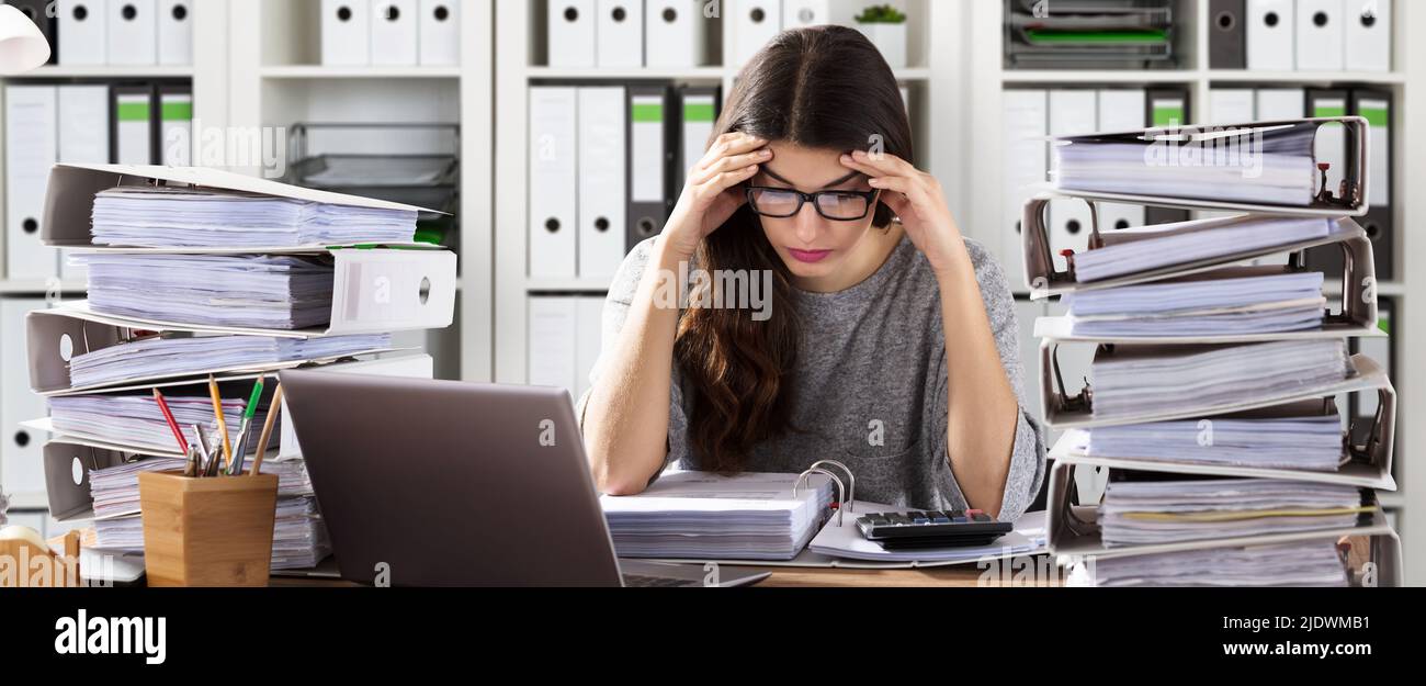 Inquiets Businesswoman Working at Office avec pile de dossiers sur 24 Banque D'Images