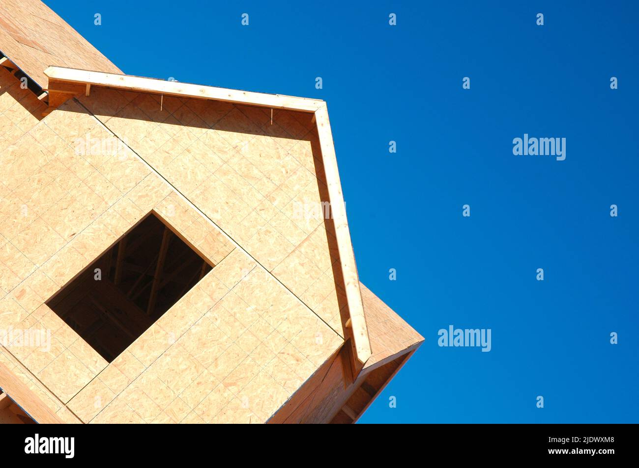 Nouvelle construction de maison utilisant des panneaux de particules et une parement en bois avec ciel bleu clair et propre pour la copie et ou le texte Banque D'Images