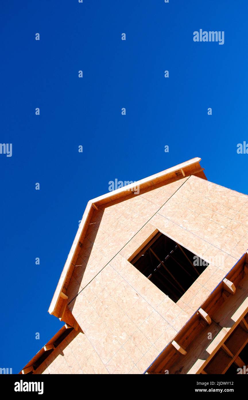 Nouvelle construction de maison utilisant des panneaux de particules et une parement en bois avec ciel bleu clair et propre pour la copie et ou le texte Banque D'Images