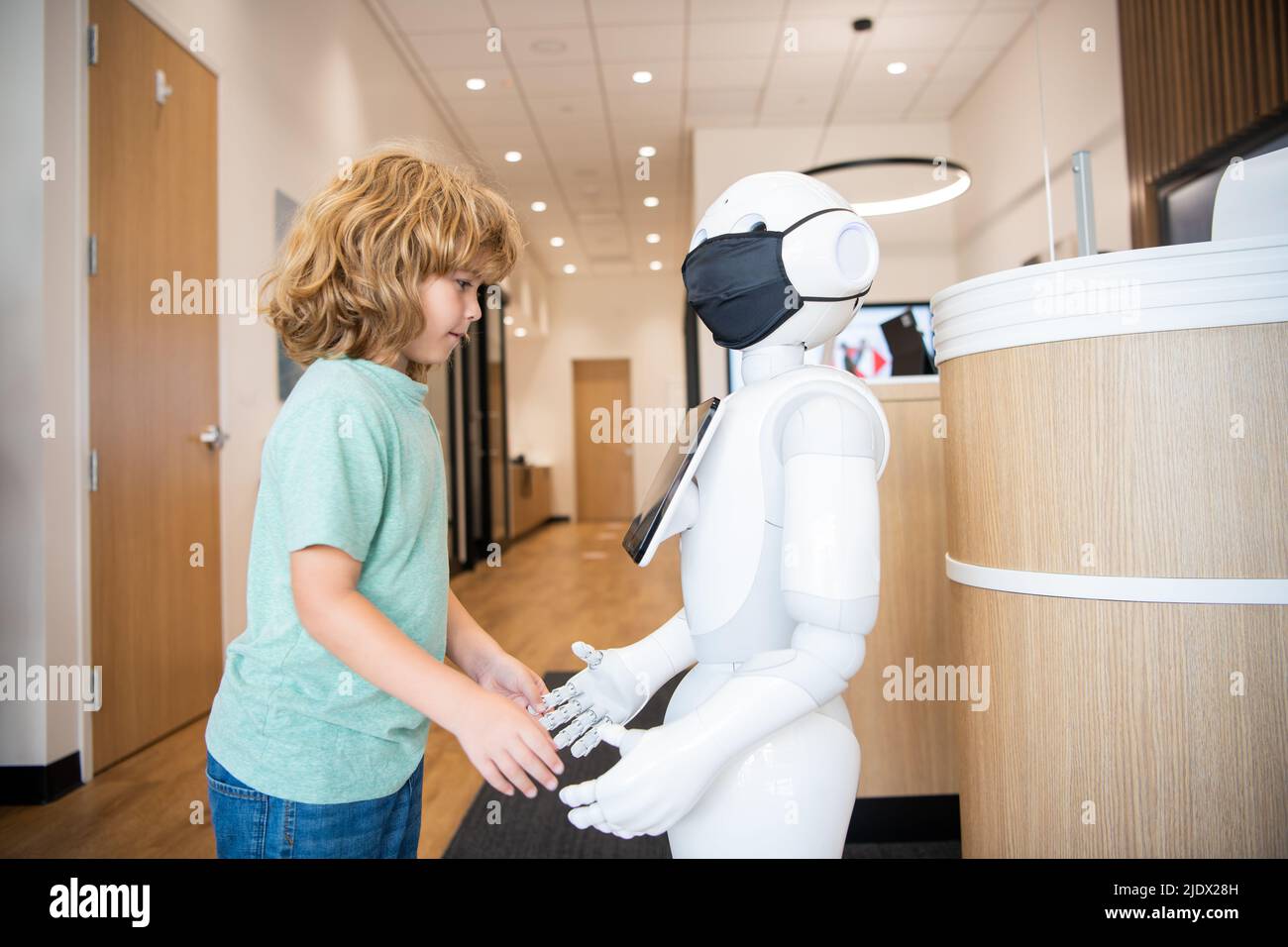 un enfant occupé interagit avec l'intelligence artificielle du robot, la communication Banque D'Images