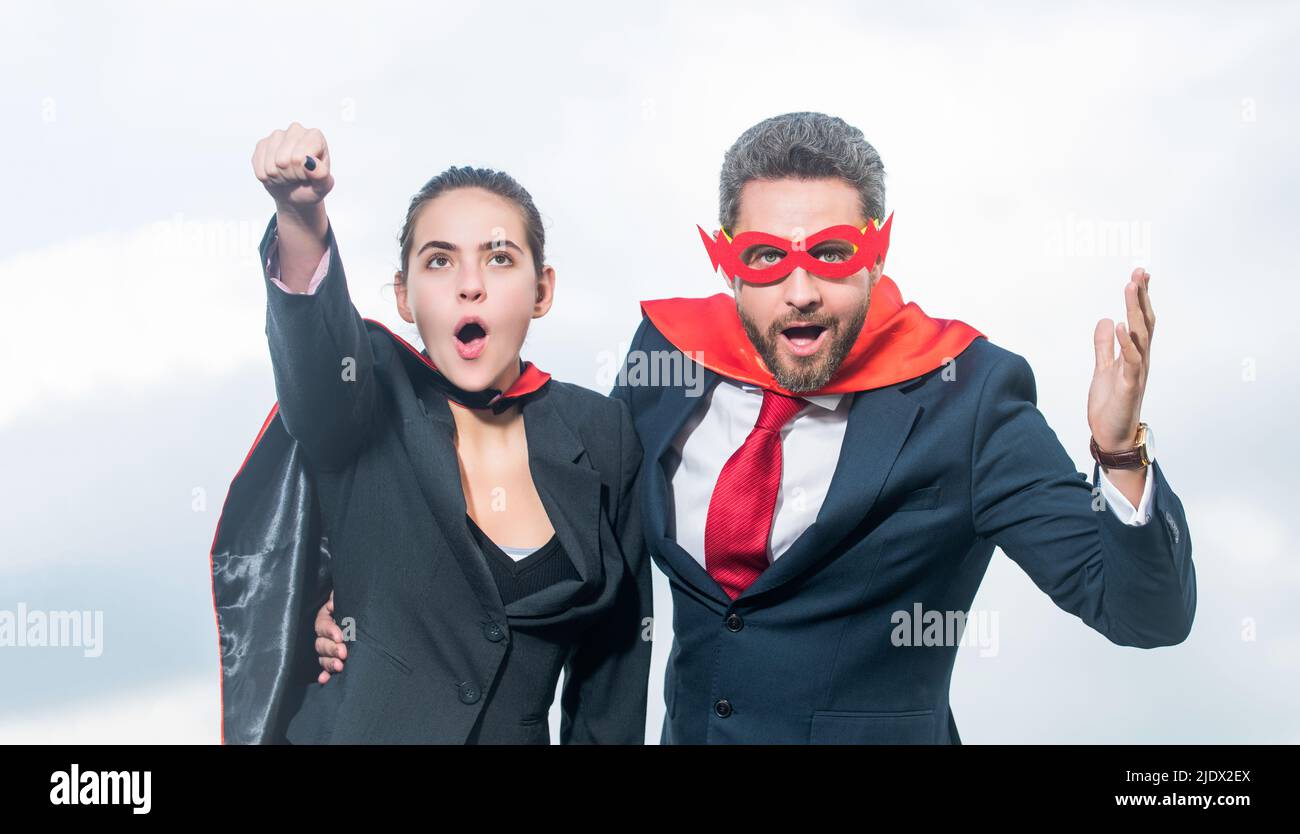 un couple d'affaires stupéfait dans un costume super-héros sur fond de ciel Banque D'Images