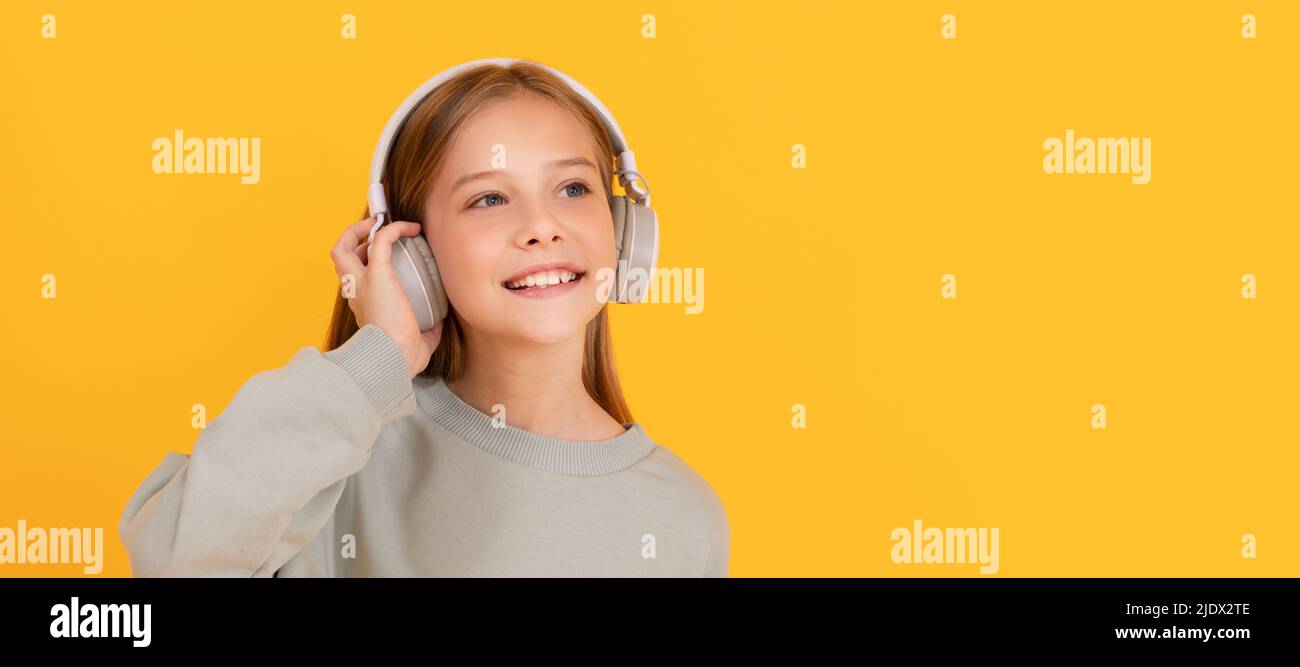 mélomane. écoutez de la musique. accessoire de casque sans fil. Portrait d'enfant avec casque, affiche horizontale. Fille écoutant de la musique, bannière Banque D'Images