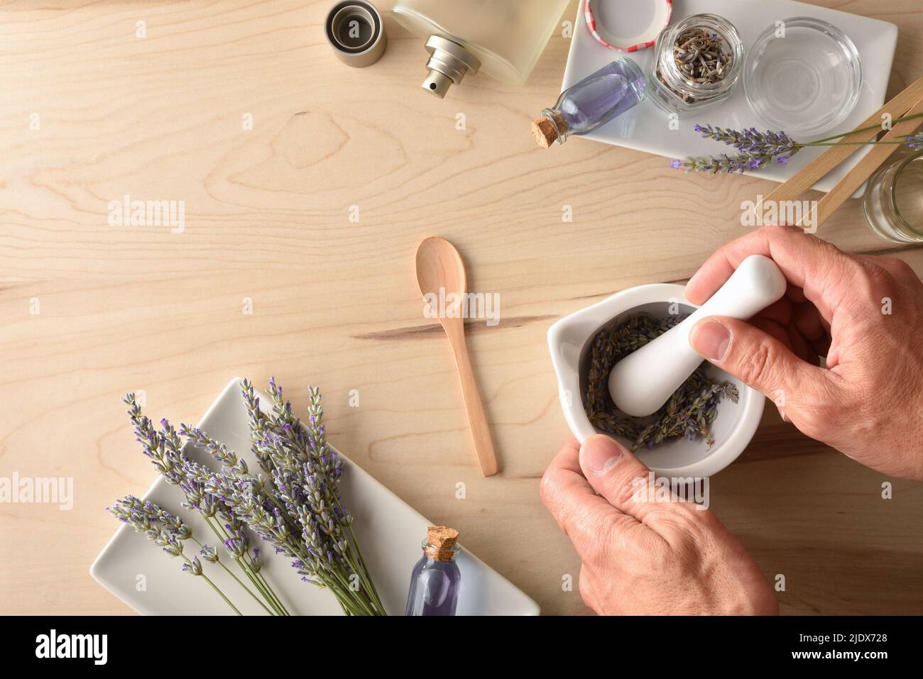 Personne faisant des parfums de lavande maison parfumés à l'essence de lavande naturelle avec des éléments pour la préparation et des récipients et des pointes. Vue de dessus. Banque D'Images