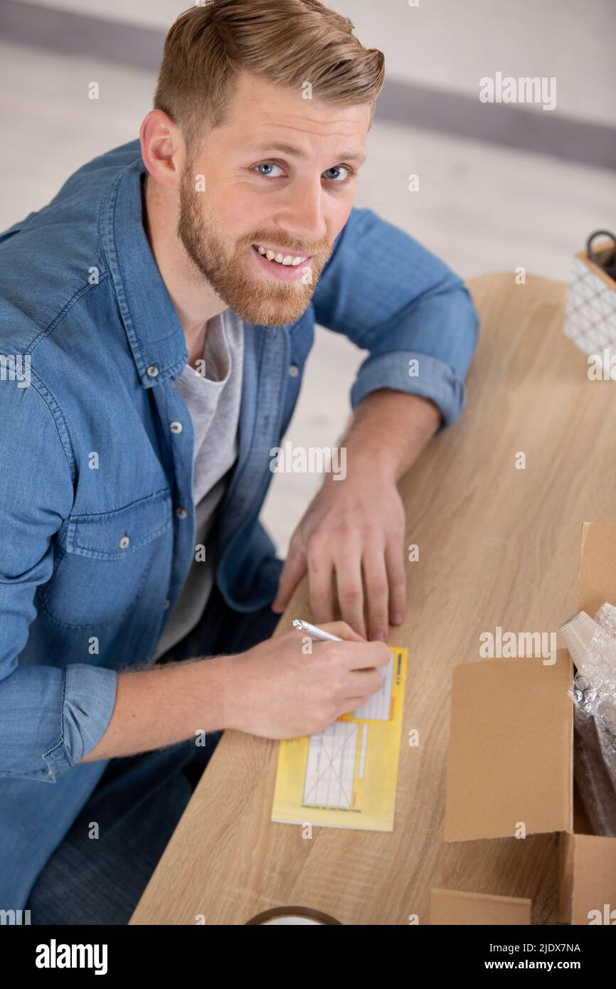 un beau homme écrit un bon de livraison Banque D'Images