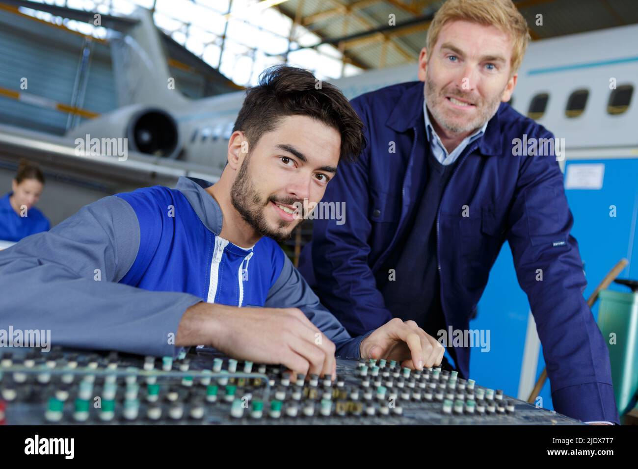 jeune technicien homme réglant le panneau de commande aéronautique démonté Banque D'Images