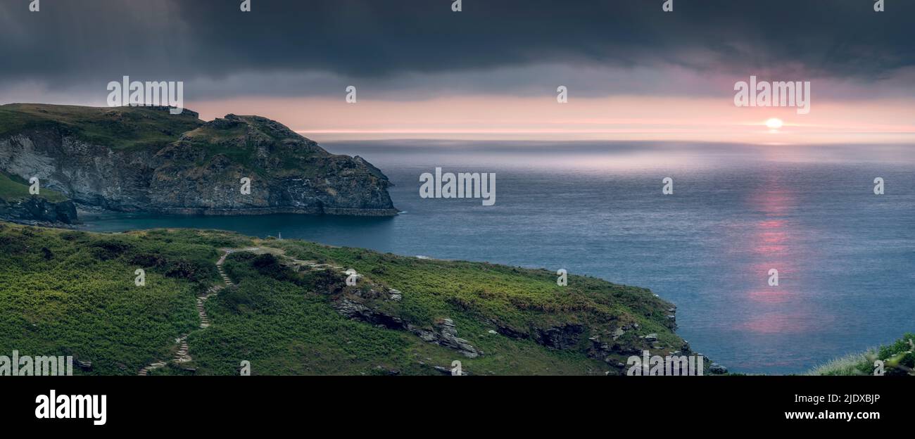 Après une chaude journée d'été en juin, les nuages commencent à s'accumuler et à s'assombrir au-dessus du promontoire dans la Cornouailles du Nord tandis que le soleil se couche sur le sentier côtier Banque D'Images