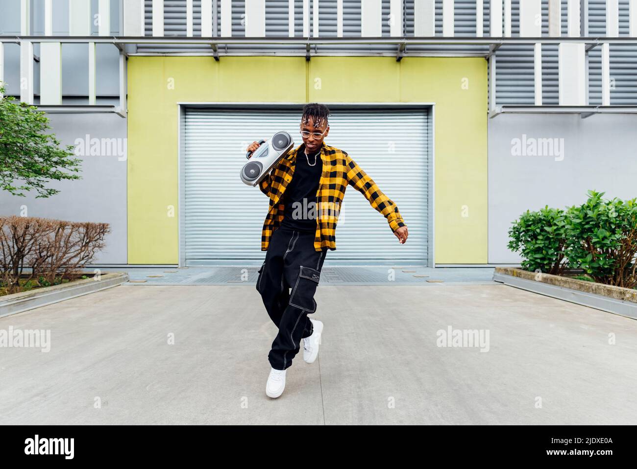Un jeune homme heureux avec un boom dansant devant l'obturateur Banque D'Images