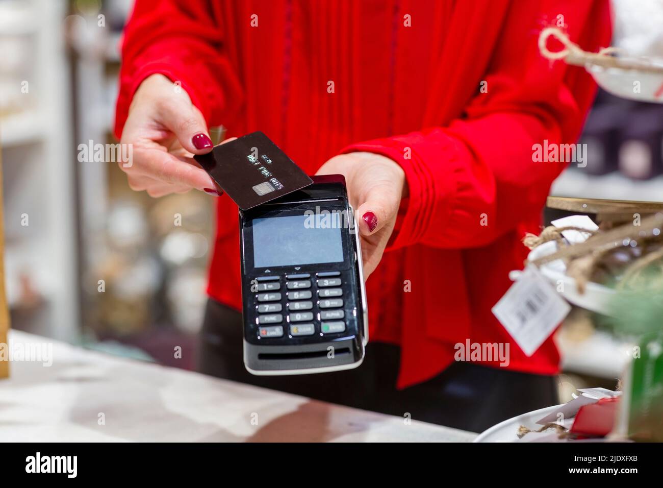 Femme payant avec une carte de crédit dans le magasin de Noël Banque D'Images