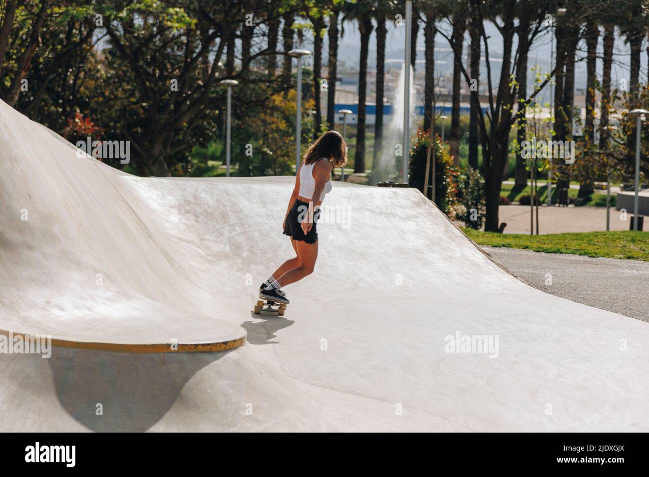 Femme skateboard sur une rampe de sport Banque D'Images