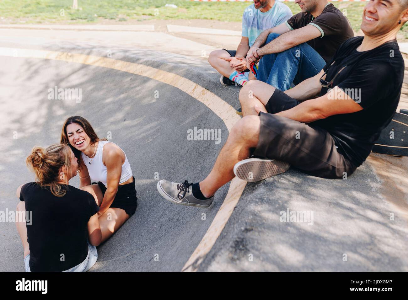 Des amis heureux s'amusant au parc de skateboard Banque D'Images
