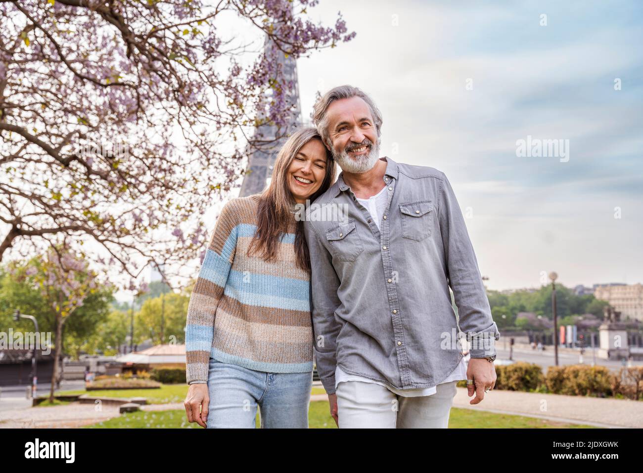 Heureux couple d'âge mûr marchant ensemble devant la tour Eiffel, Paris, France Banque D'Images