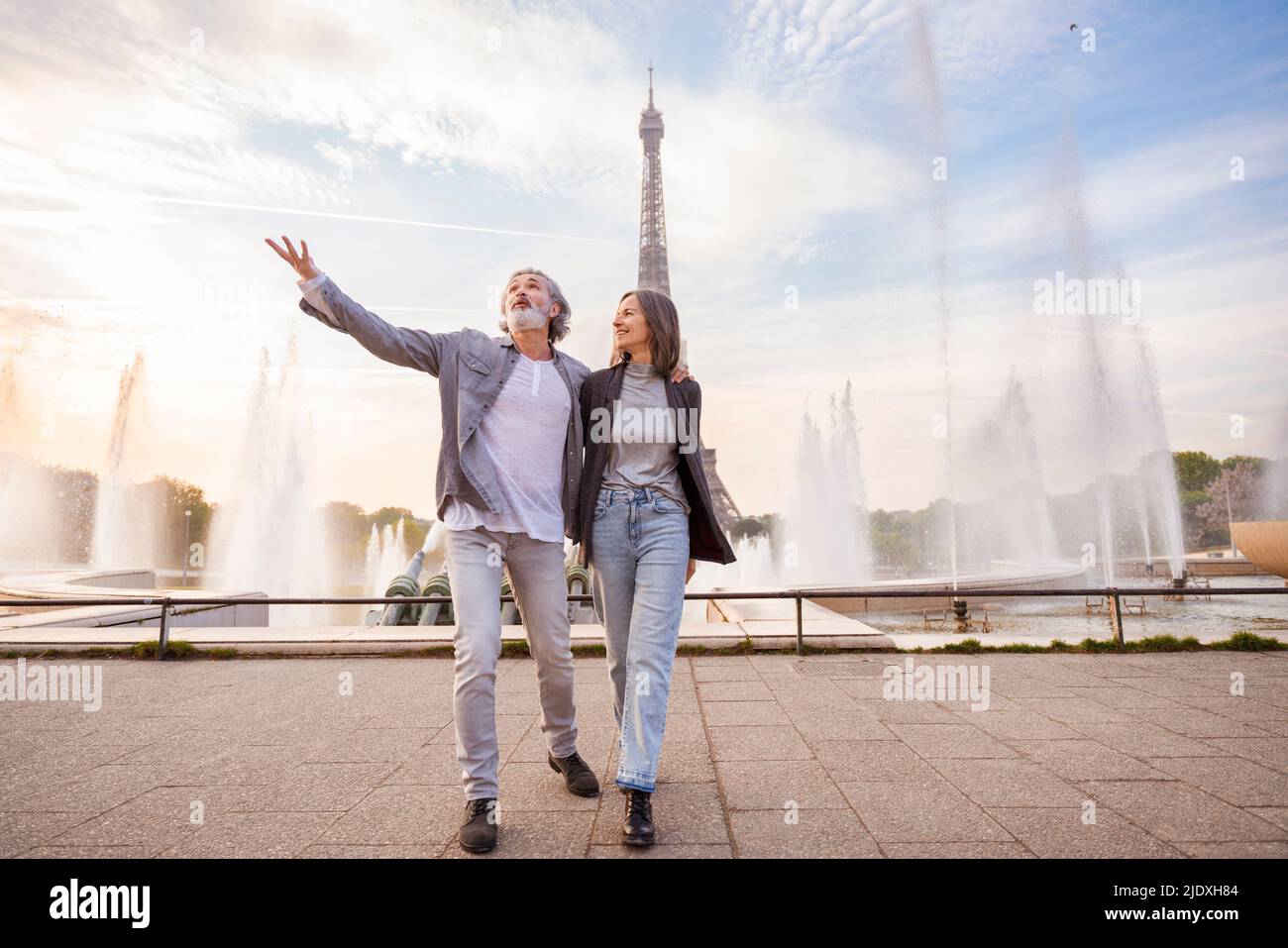 Couple mûr souriant en face de la fontaine et de la Tour Eiffel, Paris, France Banque D'Images
