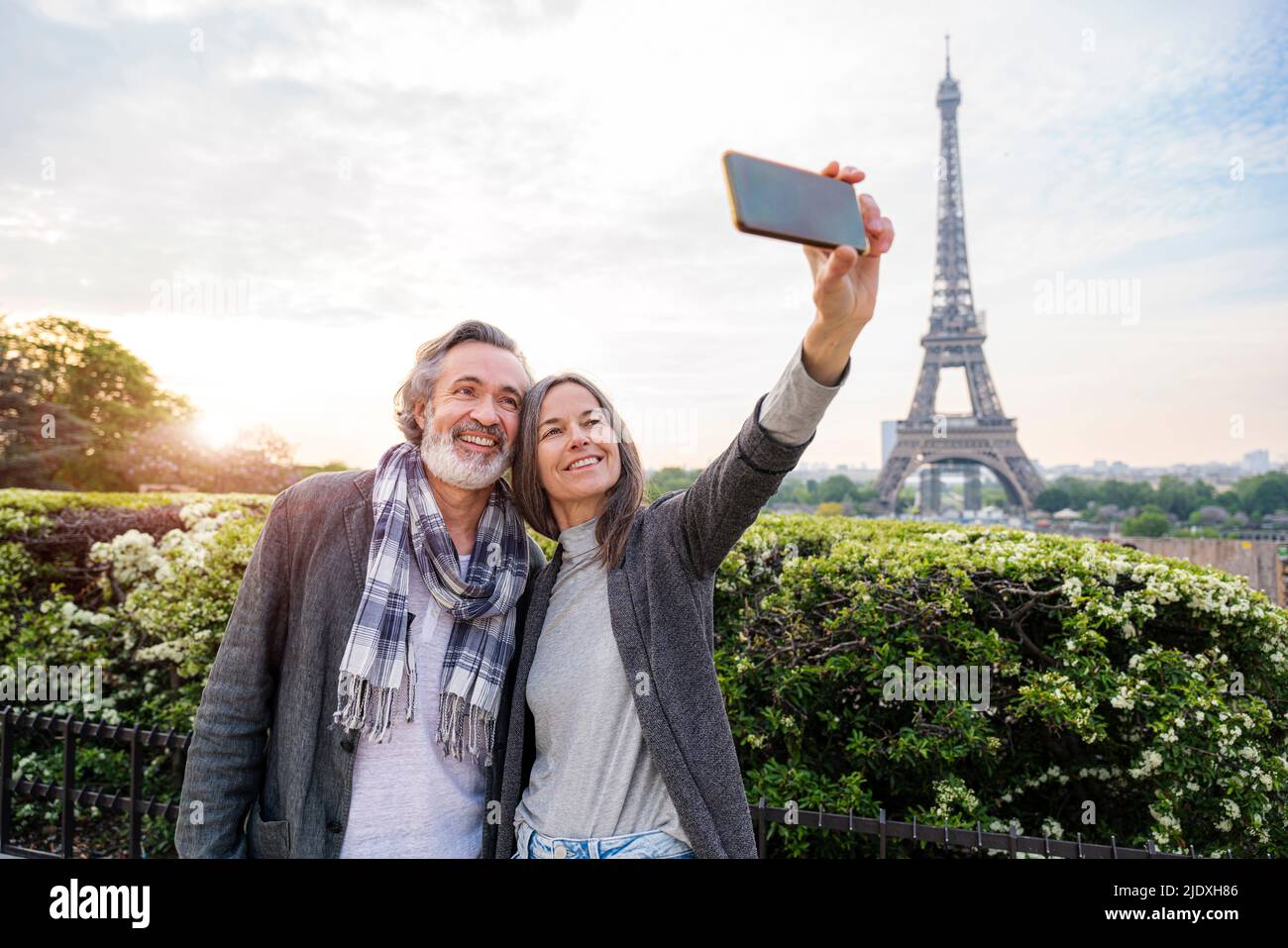 Bonne femme qui prend le selfie avec l'homme à travers le smartphone en face de la Tour Eiffel, Paris, France Banque D'Images
