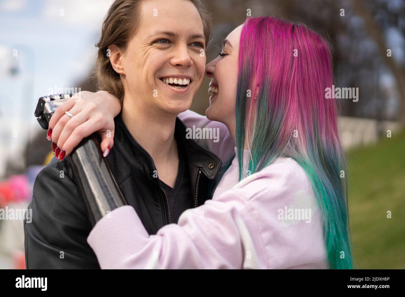 Femme souriante avec un membre artificiel embrassant un petit ami Banque D'Images Femme souriante avec un membre artificiel embrassant un petit ami Banque D'Images