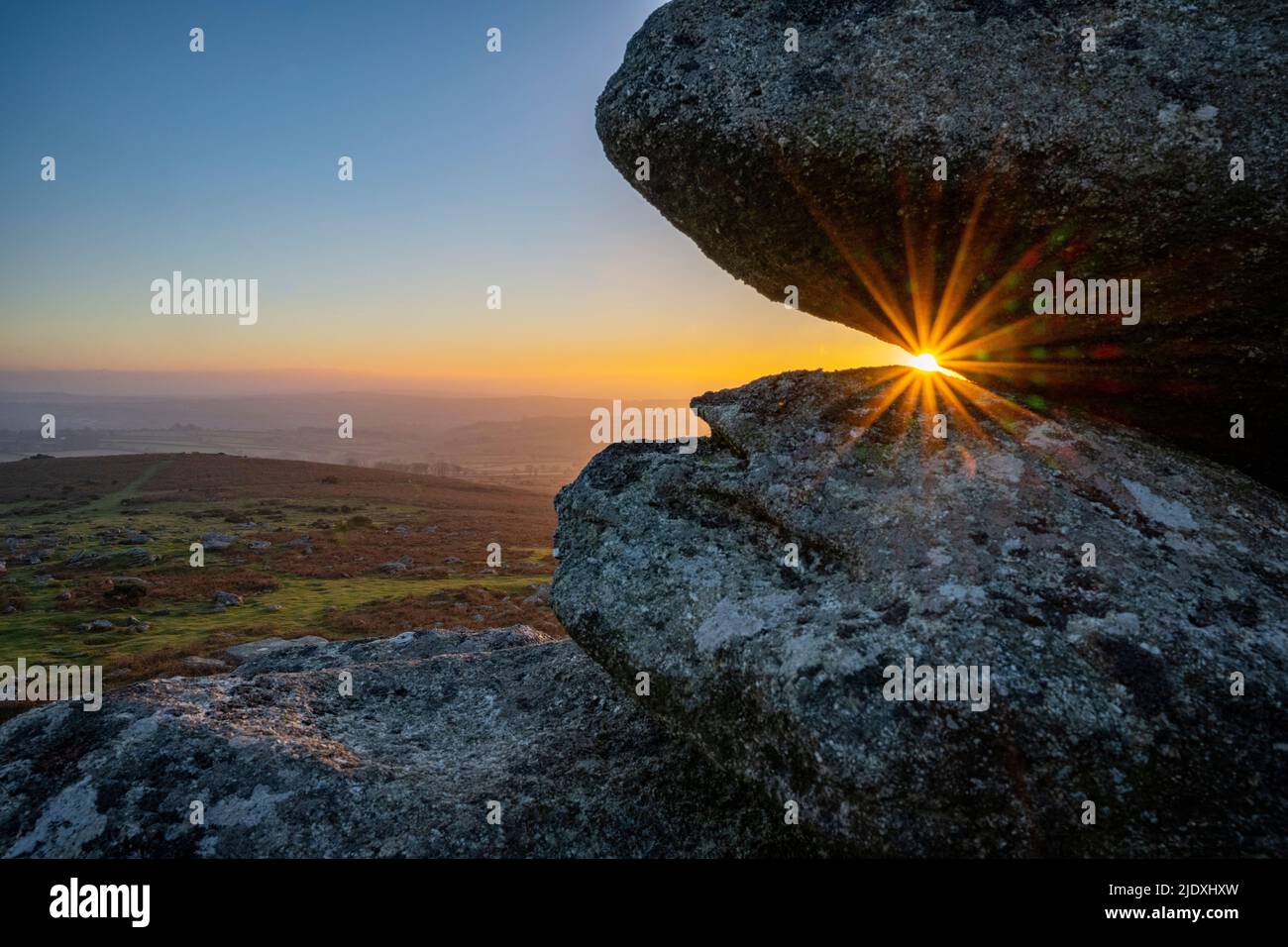 Royaume-Uni, Angleterre, soleil derrière les Tors à Dartmoor Banque D'Images