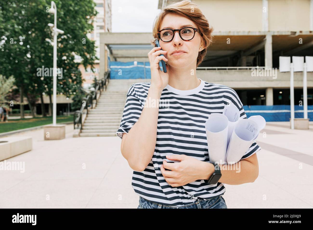 Architecte tenant des modèles parlant sur un smartphone Banque D'Images