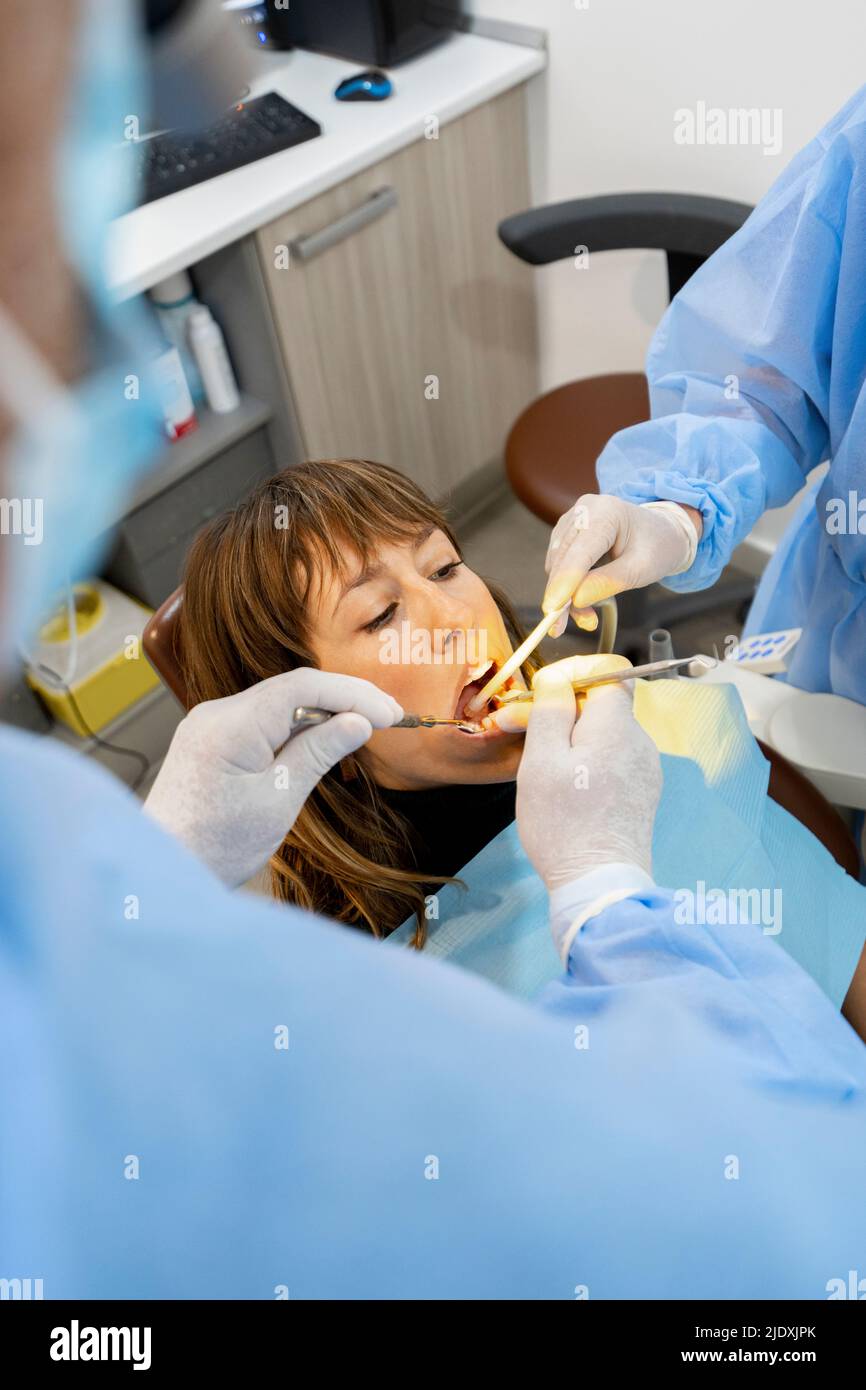 Dentistes traitant la femme à la clinique Banque D'Images