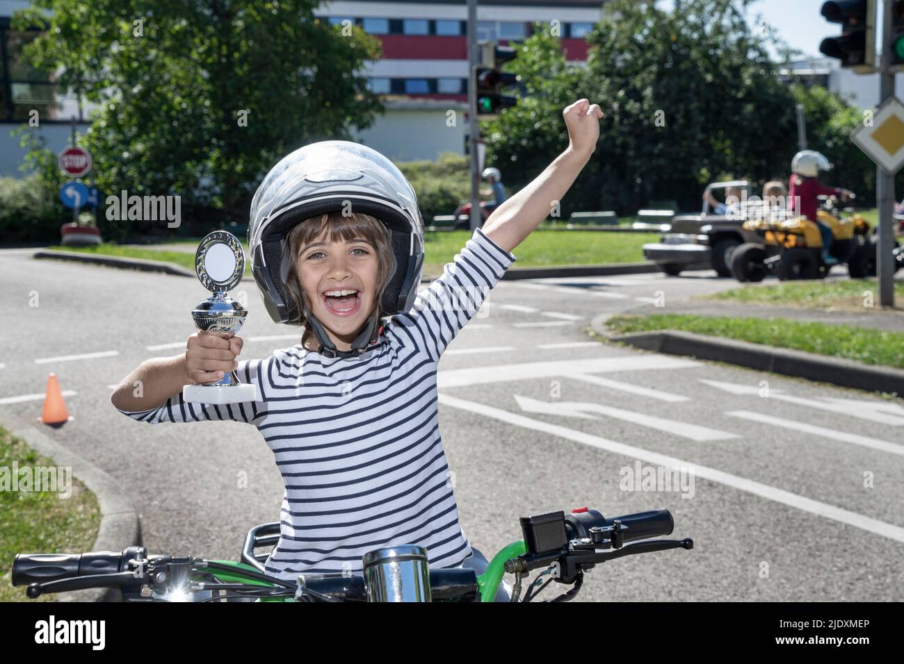 Joyeux garçon tenant le trophée assis sur quadbike Banque D'Images