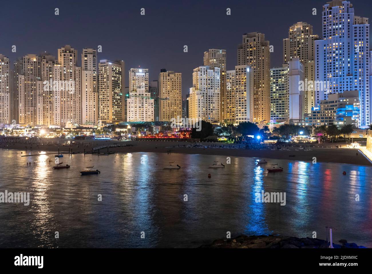 Emirats Arabes Unis, Dubaï, Skyline des appartements côtiers illuminés la nuit Banque D'Images