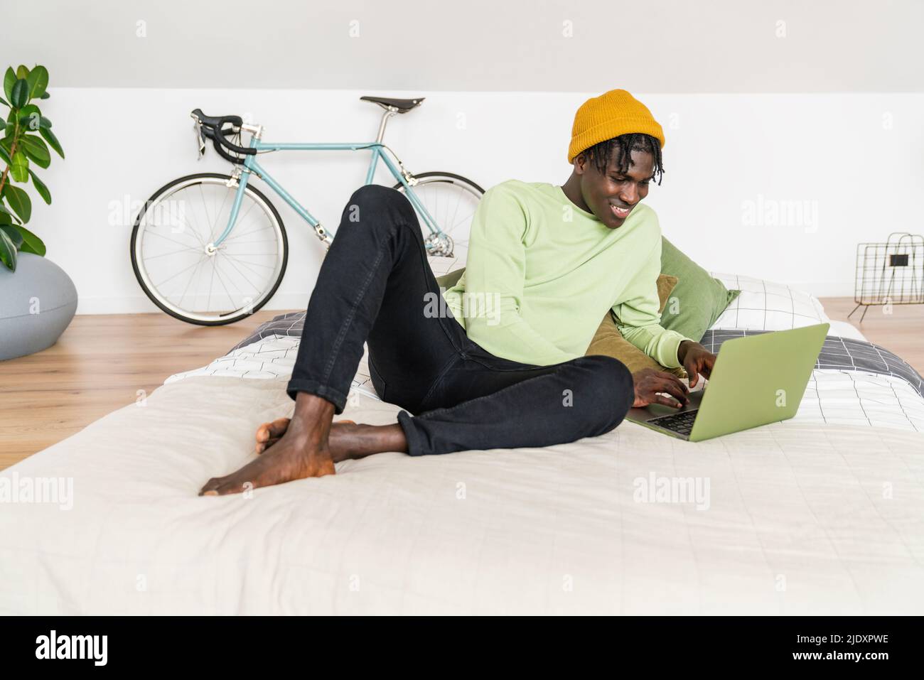 Homme d'affaires souriant travaillant sur un ordinateur portable dans la chambre Banque D'Images