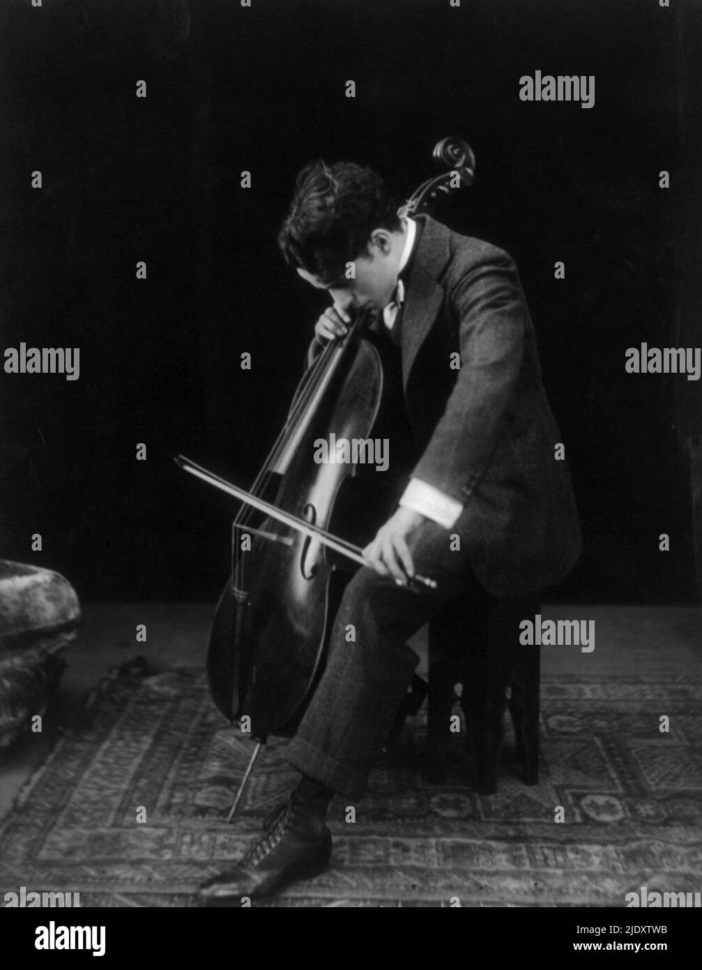 Chaplin jouant le violoncelle en 1915 Banque D'Images