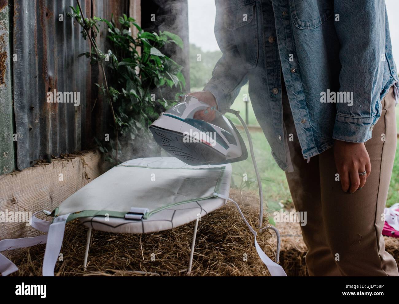 femme repassant des produits pour une marque de photoshoot dans les coulisses Banque D'Images